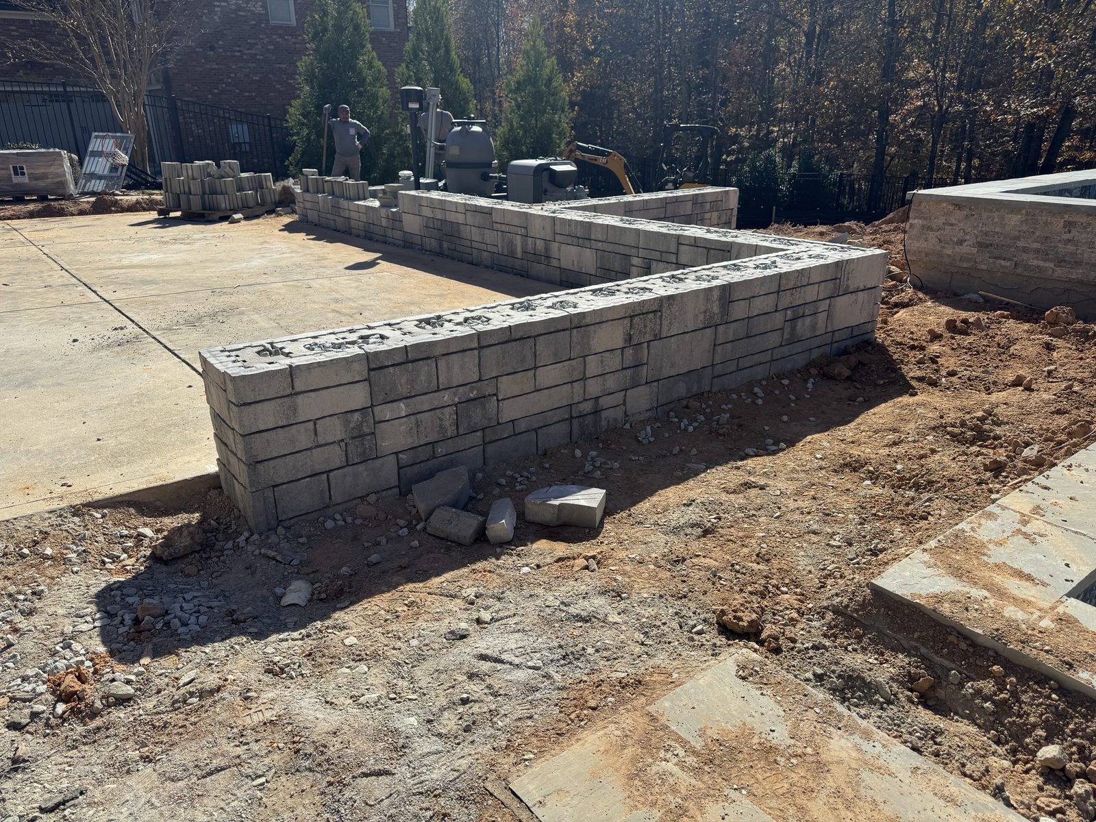 Partially completed retaining wall beside concrete patio