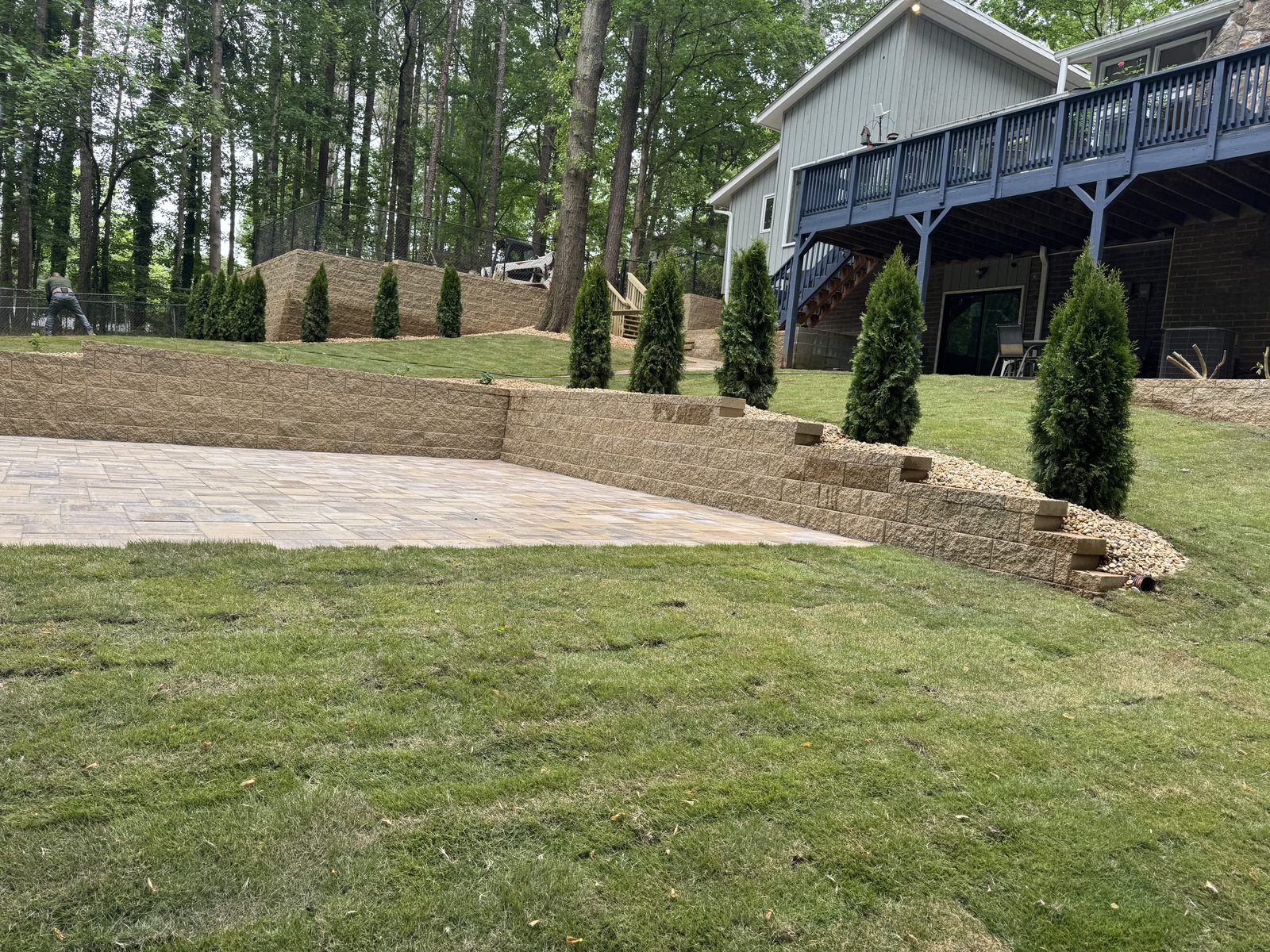 Finished backyard with lawn, patio, and retaining wall work by JDR Landscaping