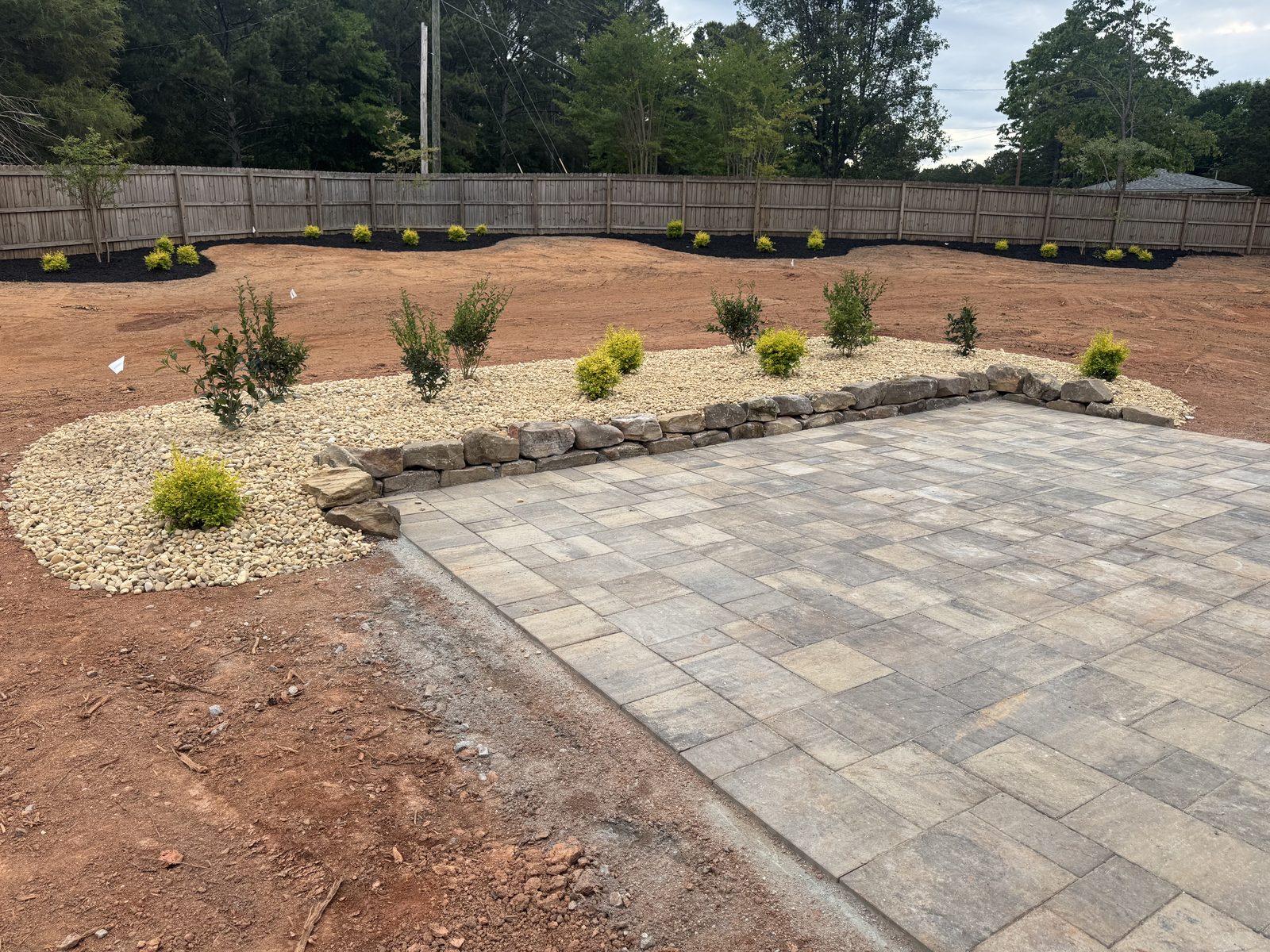 Before patio and lawn transformation with bare soil around the finished patio